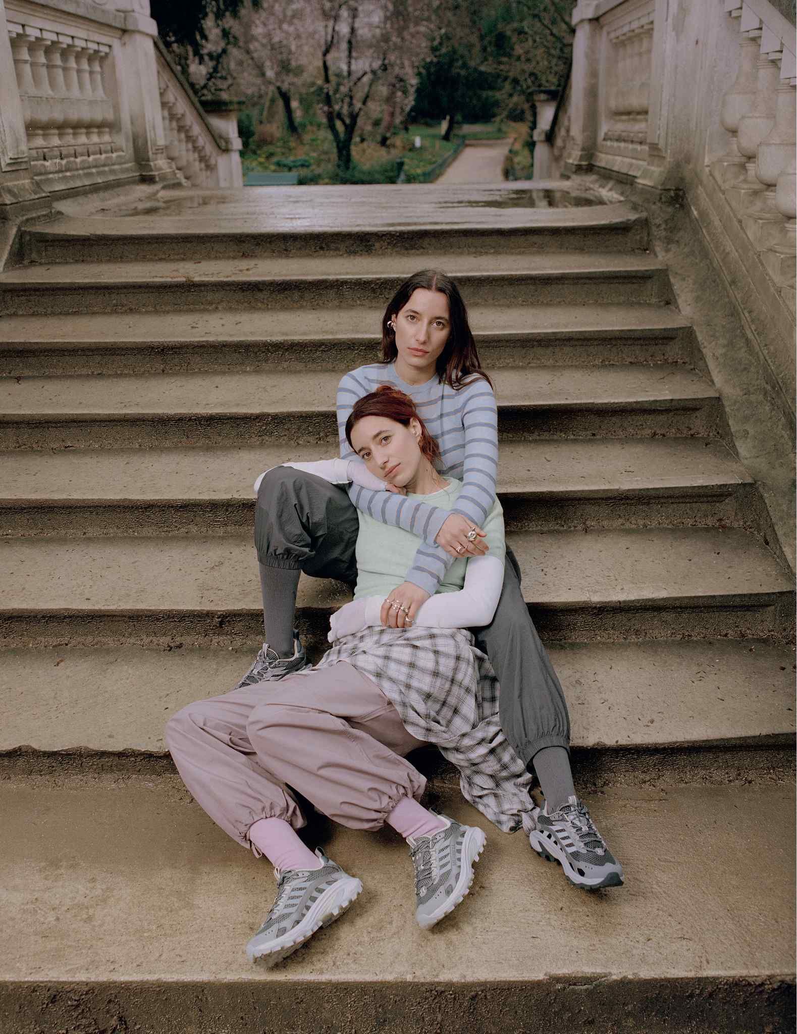 Two women sitting together on an outdoor staircase